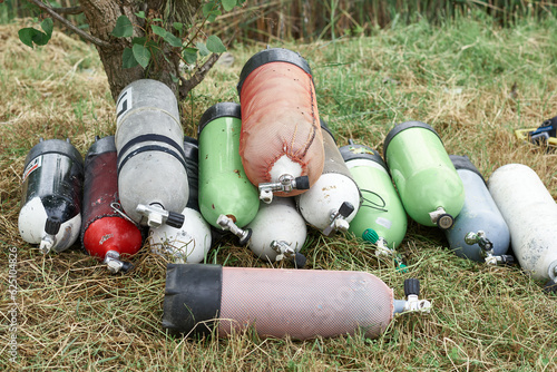 Heap of gas cylinders for scuba diving lie on the grass, concept active lifestyle, extreme sports
