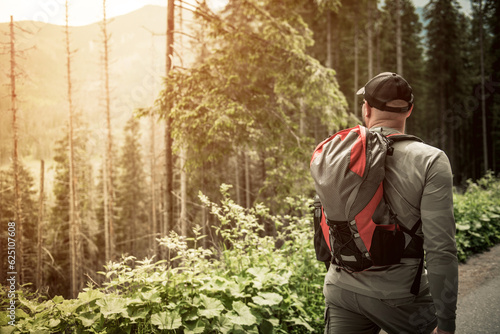 Hike in the forest in the mountains. A man with a backpack while trekking. © peterzayda