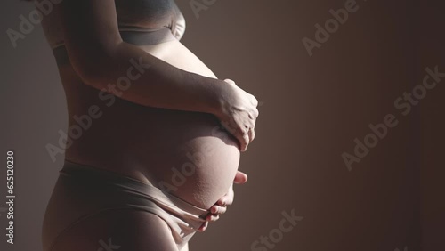 pregnant woman. health pregnancy motherhood procreation concept. close-up belly of a pregnant woman. woman waiting for indoors a newborn baby. pregnant woman holding her belly sunlight