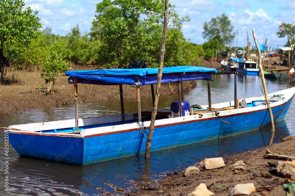 Obraz premium Fishing boat leaning on the coast of Kenyamukan Beach, Sangatta, East Kalimantan, Indonesia in the morning.