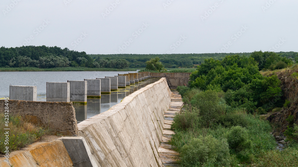River dam. Dam. Close-up of the dam. Concrete pillars in the water near the dam