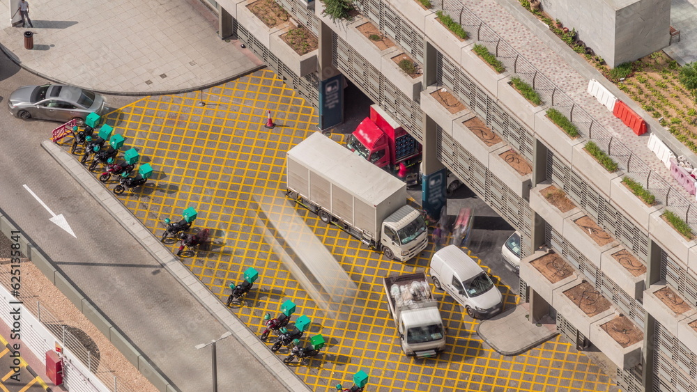 Row of food delivery service motor bikes in Dubai street aerial timelapse.