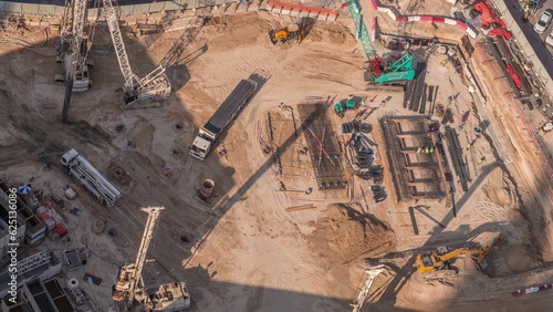 Fotografie, Obraz Aerial view construction site with a foundation pit of new skyscraper timelapse