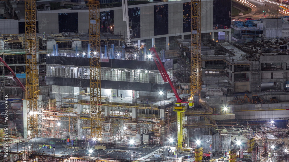 Large construction site with many working cranes night timelapse.