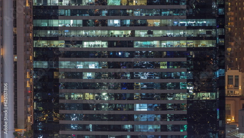 Office buildings windows illuminated at night timelapse