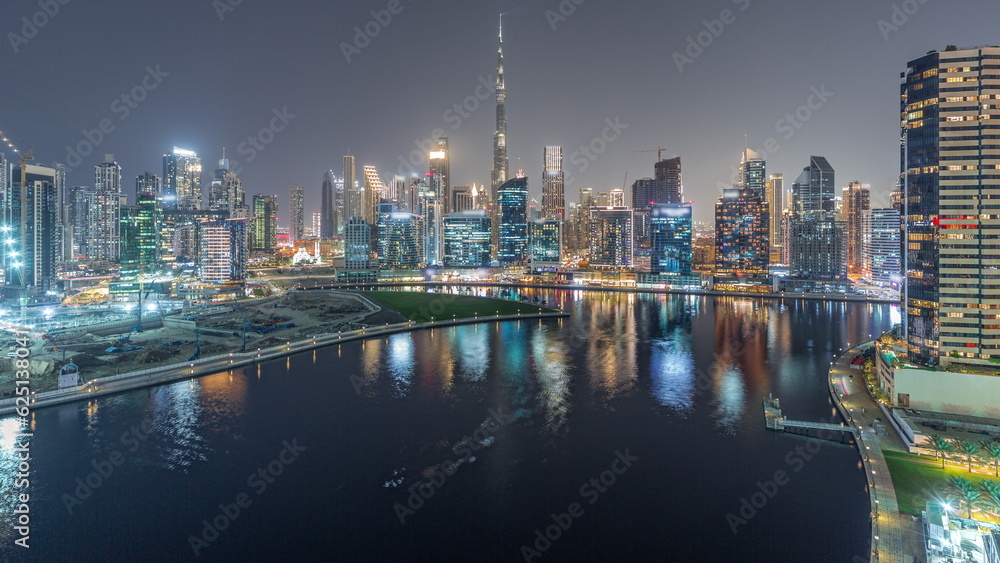 Fototapeta premium Aerial view to Dubai Business Bay and Downtown with the various skyscrapers and towers night timelapse
