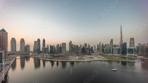 Aerial panorama of Dubai Business Bay and Downtown with the various skyscrapers and towers day to night timelapse