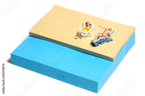 Creative miniature people toy figure photography. Sticky notes installation. A couple chilling out on beach bench at the beach. Isolated on white background