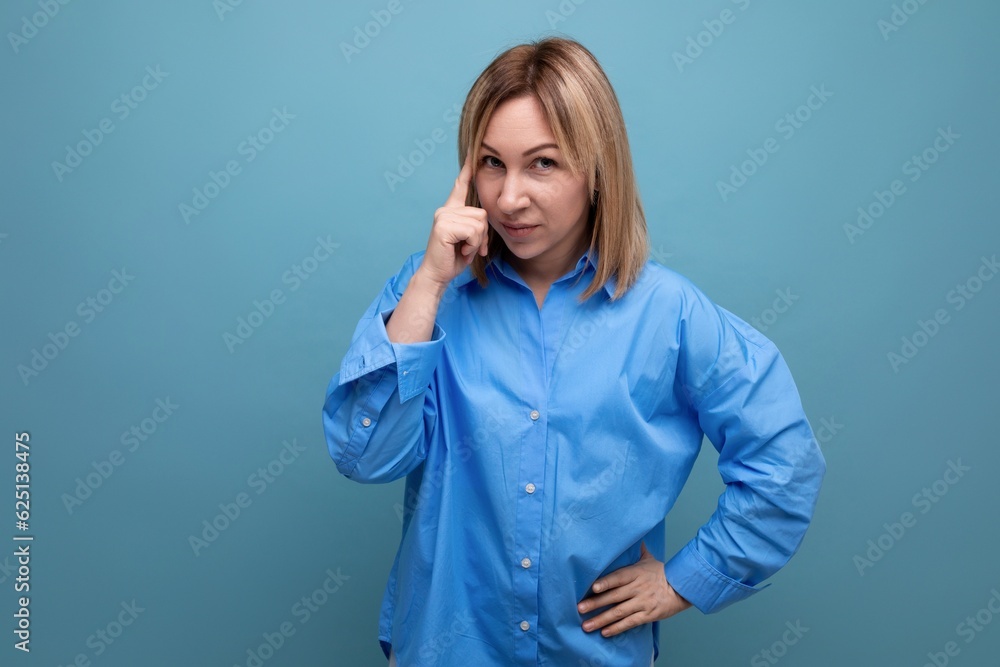 cute young woman in casual shirt showing think gesture on blue background cute young woman in casual shirt showing think gesture on blue background