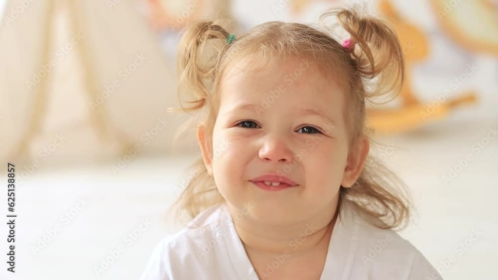 close-up portrait little child girl blond with blue eyes smiling in the children's room close-up portrait little child girl blond with blue eyes smiling in the children's room