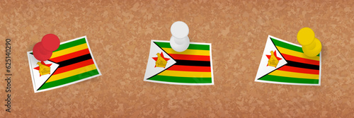 Zimbabwe flag pinned in cork board, three versions of Zimbabwe flag.