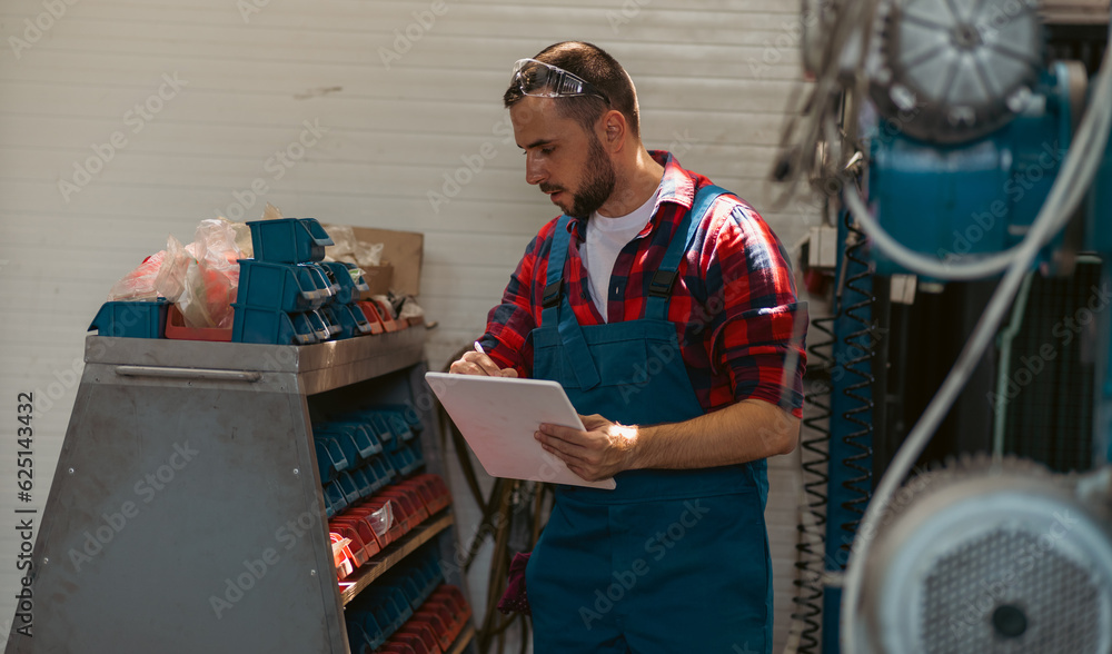 The employe at the work, writing down some digits, which he is reading of the machine The employe at the work, writing down some digits, which he is reading of the machine