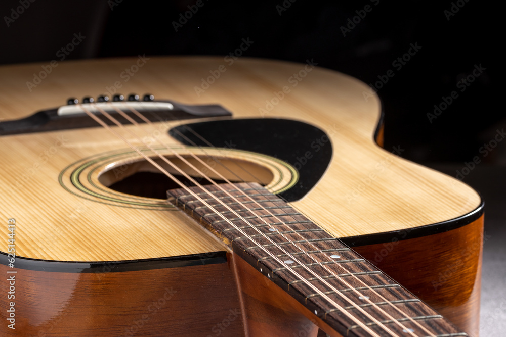 Fototapeta premium Classical guitar close up. Acoustic guitar on wood background.Music instrument concept