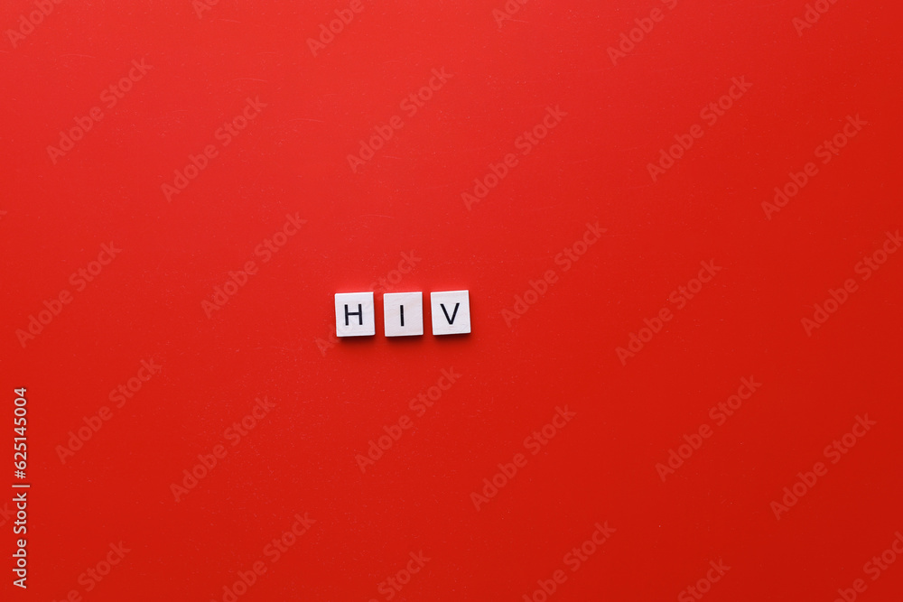 HIV Day. AIDS Day. Flatly inscription hiv from wooden letters on a red background - obrazy, fototapety, plakaty 