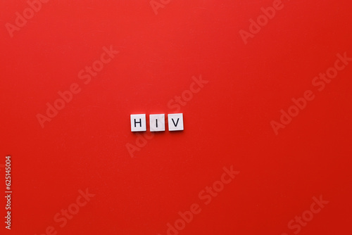 HIV Day. AIDS Day. Flatly inscription hiv from wooden letters on a red background