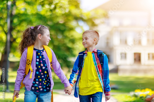 Girl and boy going from school by holding hands.