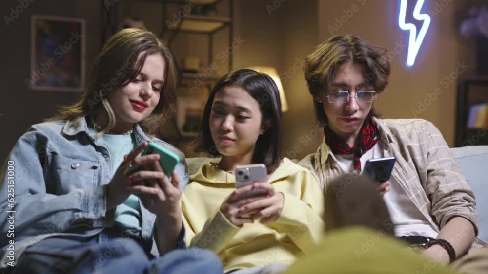 Group of multiethnic friends use smartphones. Close multiracial friends teenagers watch memes on social networks and laugh. Life in virtual world, life is impossible without Internet, social networks. Group of multiethnic friends use smartphones. Close multiracial friends teenagers watch memes on social networks and laugh. Life in virtual world, life is impossible without Internet, social networks.