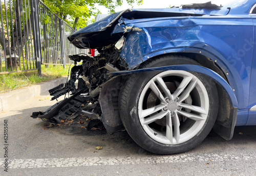 A blue car crashed accident. Car accident on the road. Car crash accident on street. Damaged vehicle. Car insurance concept. Vehicle get big damage by accident on the road. © Aleksei