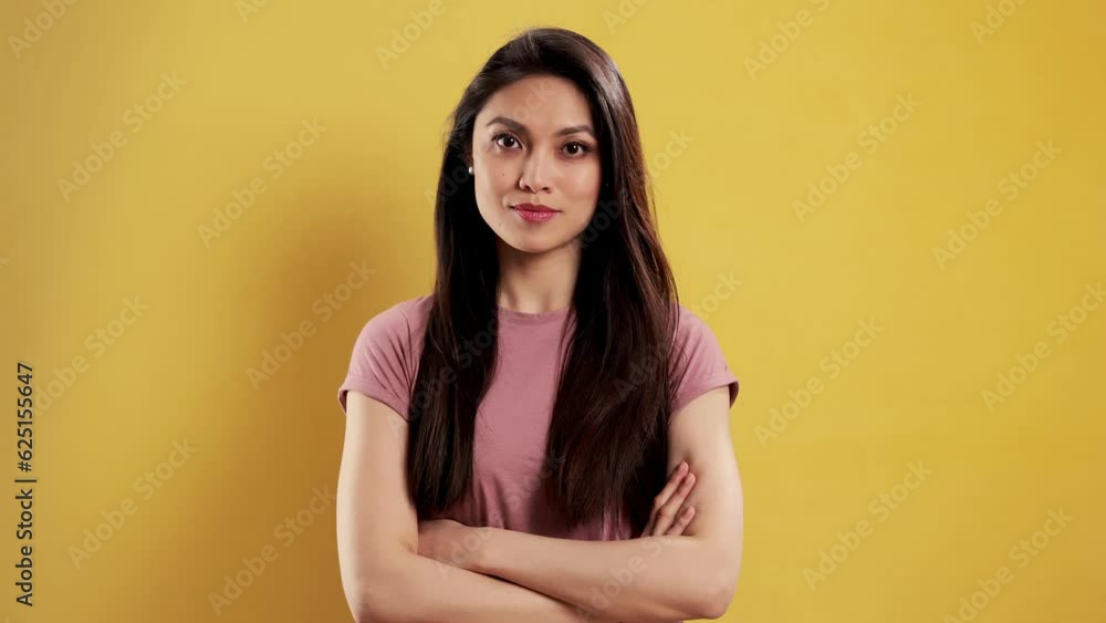 Asian Girl with a confident smile in a studio posing for the camera - extreme slow motion shot Asian Girl with a confident smile in a studio posing for the camera - extreme slow motion shot
