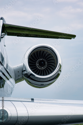 Close-up of jet engine turbine on business aircraft against clear blue sky