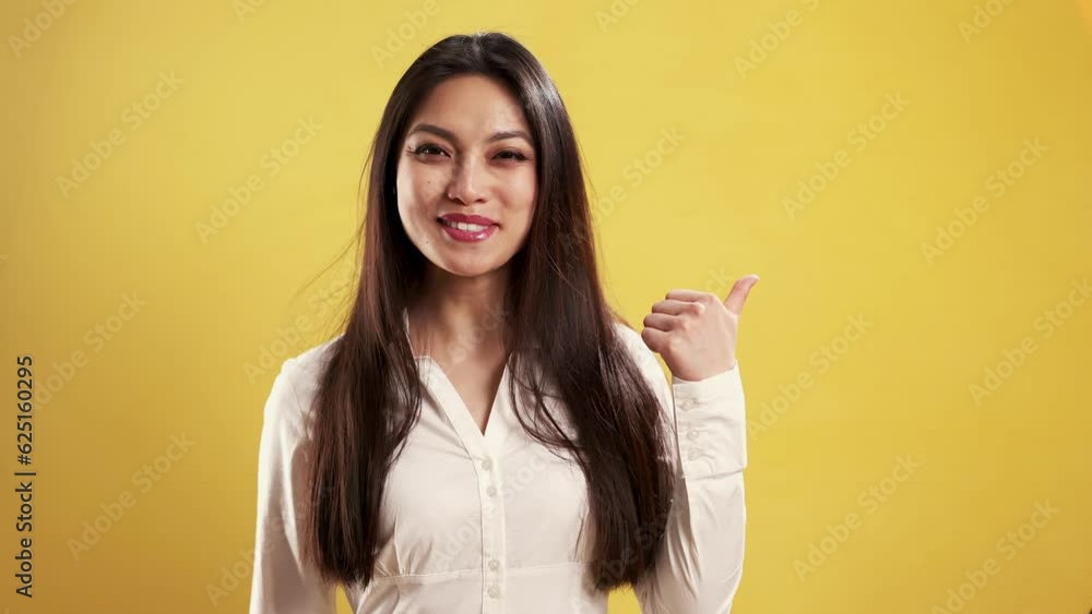 Asian Girl with a confident smile in a studio pointing beside her - extreme slow motion shot Asian Girl with a confident smile in a studio pointing beside her - extreme slow motion shot