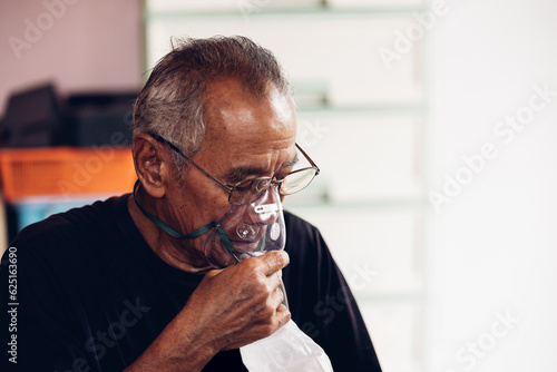 Elderly Senior Man wear oxygen inhaler device for helping breath respiratory. Patient use portable oxygen at home. Patients with respiratory disorders. portable oxygen concentrator or oxygen generator