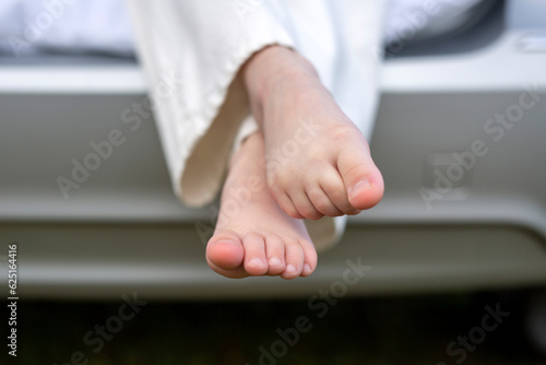 Feet of a child sitting in the trunk of a car