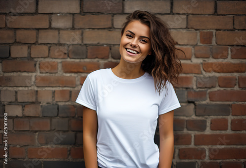 Beautiful smiling woman in a white shirt posing on a brick wall