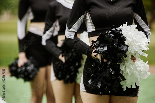 Фотография Close-up of group of cheerleading women dancing with pompom outdoors