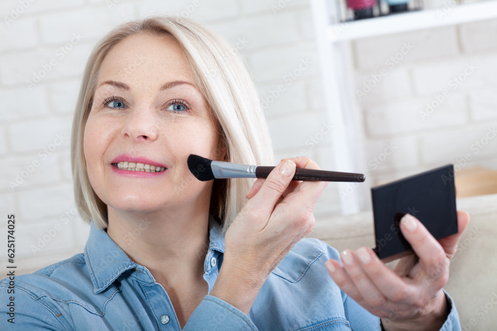 Feminine Grace. Woman is doing makeup in front of the mirror. A mesmerizing photo capturing a woman's delicate hands expertly adorning her face with makeup, as she prepares for a special occasion. Feminine Grace. Woman is doing makeup in front of the mirror. A mesmerizing photo capturing a woman's delicate hands expertly adorning her face with makeup, as she prepares for a special occasion.