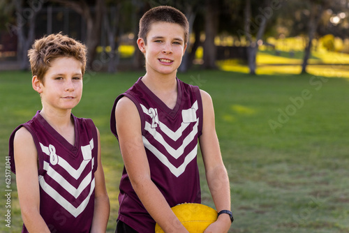 two schoolboys in football uniform standing outdoors photo