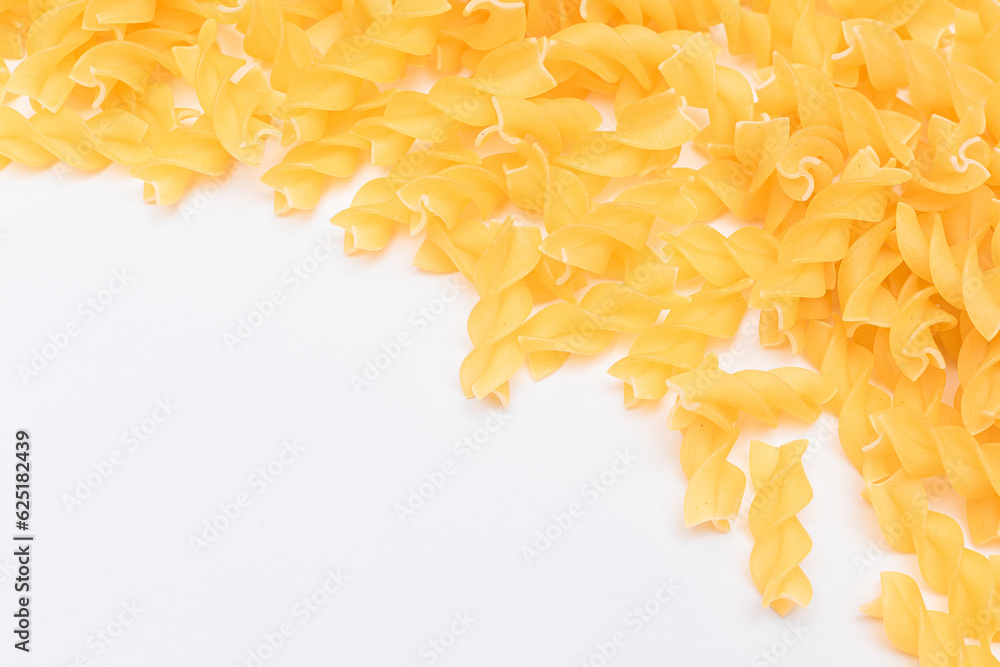 Fototapeta premium Uncooked Fusilli Pasta with Copy Space on White Background. Raw and Dry Macaroni. Fat and Unhealthy Food - Flat Lay