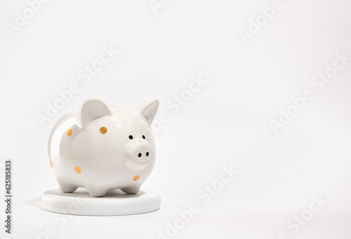 Money box pig on a round white stand. Safe deposits and savings concept. Copy space for text.