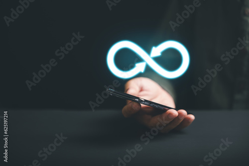 Принти на полотні Businessman holds smartphone with infinity symbol, representing unlimited connection in data technology, future unlimited