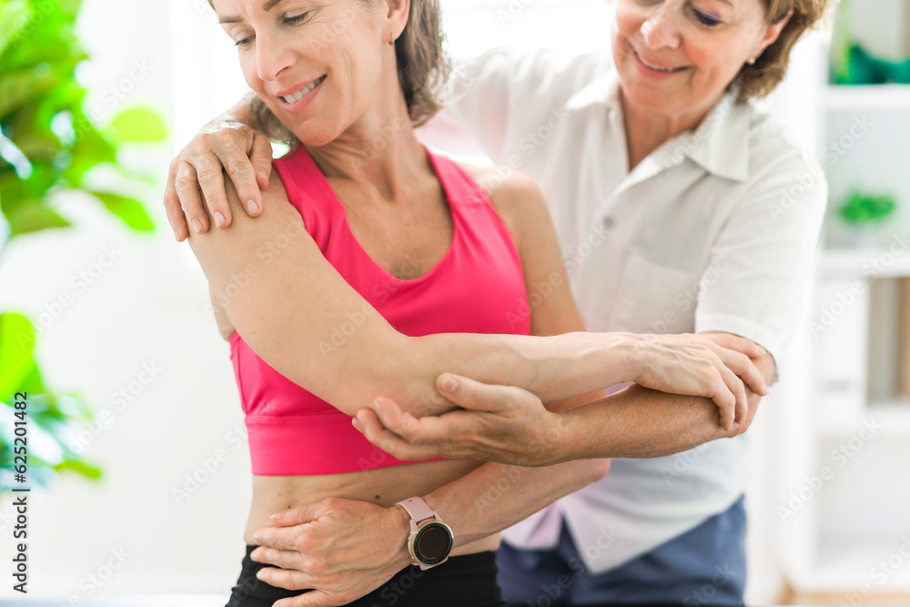 elderly Physiotherapist working with sporty patient in clinic elderly Physiotherapist working with sporty patient in clinic