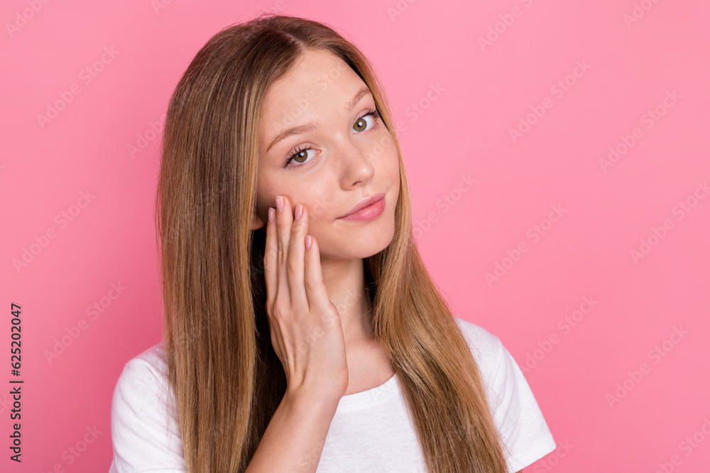 Portrait of positive lovely girl hand fingers touch cheek apply cosmetics empty space isolated on pink color background Portrait of positive lovely girl hand fingers touch cheek apply cosmetics empty space isolated on pink color background