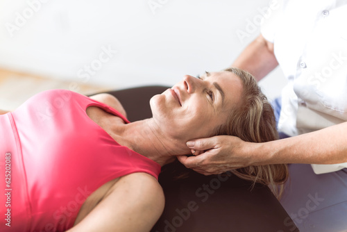 elderly Physiotherapist working with sporty patient in clinic