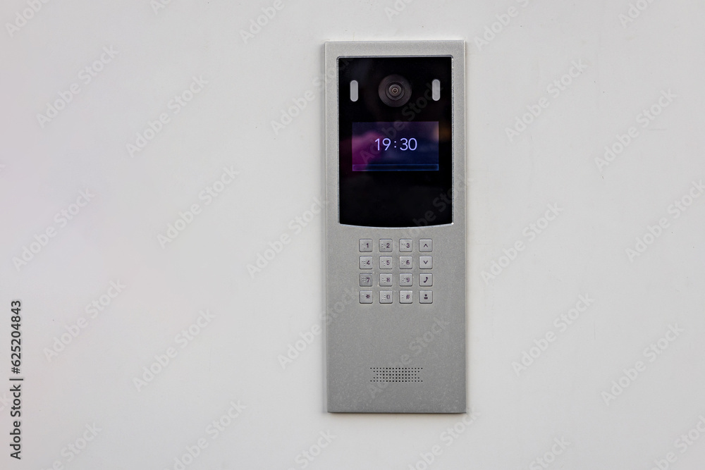Doorbell with video camera and microphone, on the white wall of an apartment building, doorbell camera. Doorbell with video camera and microphone, on the white wall of an apartment building, doorbell camera.
