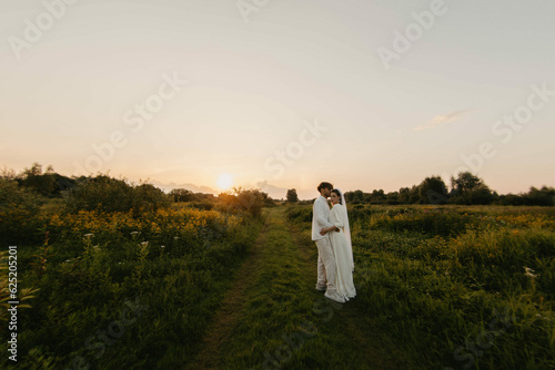 Wallpaper Mural loving couple of newlyweds at sunset in the field, the bride and groom in white wedding. Torontodigital.ca