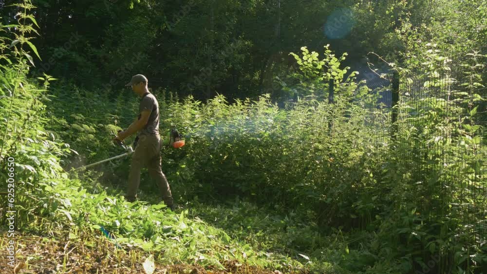 Mowing grass with a lawn trimmer, slow motion. Professional gardener mowing the lawn in garden with a petrol hedge trimmer. Lawn mowing. Garden work concept. Worker mows and moves slow motion. Mowing grass with a lawn trimmer, slow motion. Professional gardener mowing the lawn in garden with a petrol hedge trimmer. Lawn mowing. Garden work concept. Worker mows and moves slow motion.