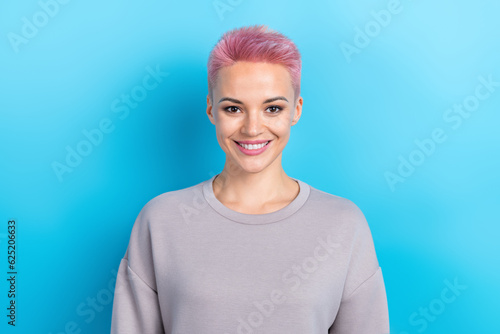 Photo of lovely pretty pleasant woman with dyed hairstyle dressed gray shirt toothy smiling at camera isolated on blue color background