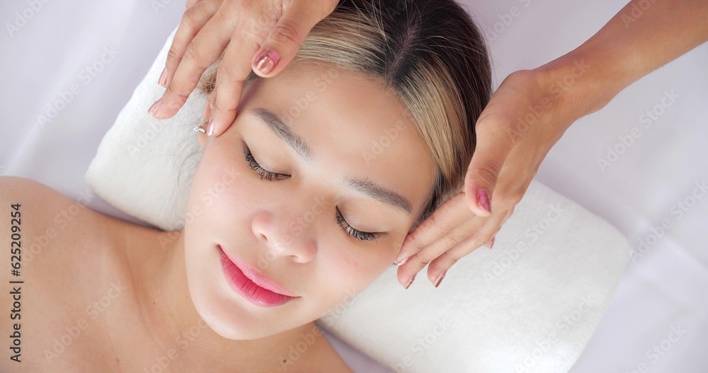 Close up face of beautiful asian women getting facial massage treatment at beauty clinic. Beauty treatment on the face. Beauty facial massage, Skin care concept