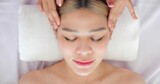 Close up face of beautiful asian women getting facial massage treatment at beauty clinic. Beauty treatment on the face. Beauty facial massage, Skin care concept