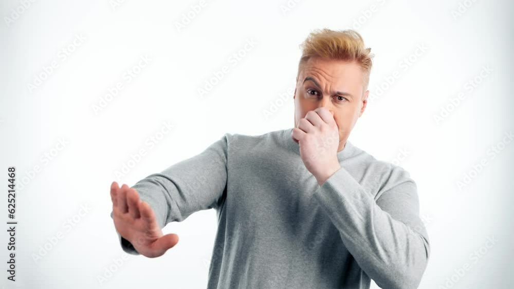 Bad smell, pinching nose man and holding breath, rejecting or banning gesture. Guy male with unpleasant expression for avoiding stinky odor in studio isolated on white background Bad smell, pinching nose man and holding breath, rejecting or banning gesture. Guy male with unpleasant expression for avoiding stinky odor in studio isolated on white background
