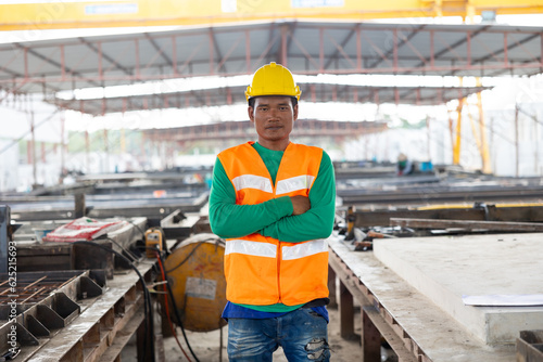 Armcrossed. Portrait Asian professional Engineer factory. Engineering worker in safety hardhat at factory industrial facilities. Heavy Industry Manufacturing Factory. Prefabricated concrete walls photo