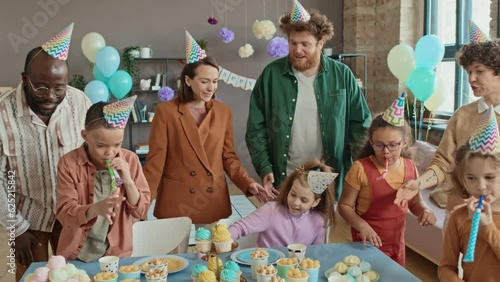 Wallpaper Mural Medium full shot of happy Caucasian mother and son standing in decorated room, greeting diverse family friends with children arriving for birthday party and sitting down together at table with sweets Torontodigital.ca