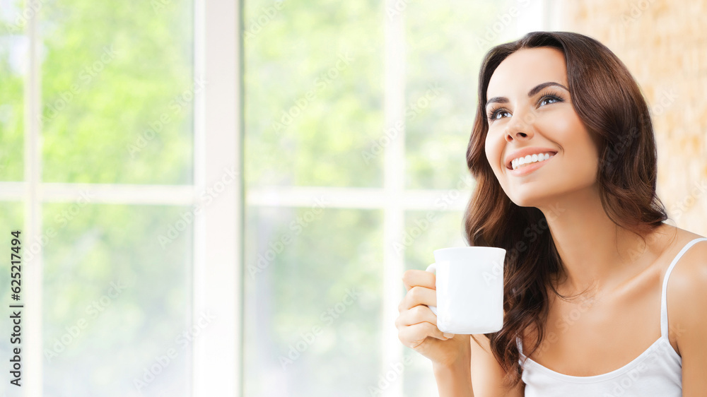 Portrait of happy smiling brunette woman in white lingerie drinking coffee or tea, looking up, at home, near window and loft style wall. Portrait of happy smiling brunette woman in white lingerie drinking coffee or tea, looking up, at home, near window and loft style wall.
