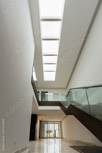 Empty living room with glass railing looking up