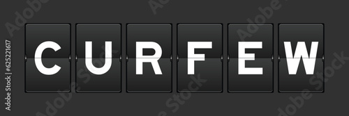 Black color analog flip board with word curfew on gray background