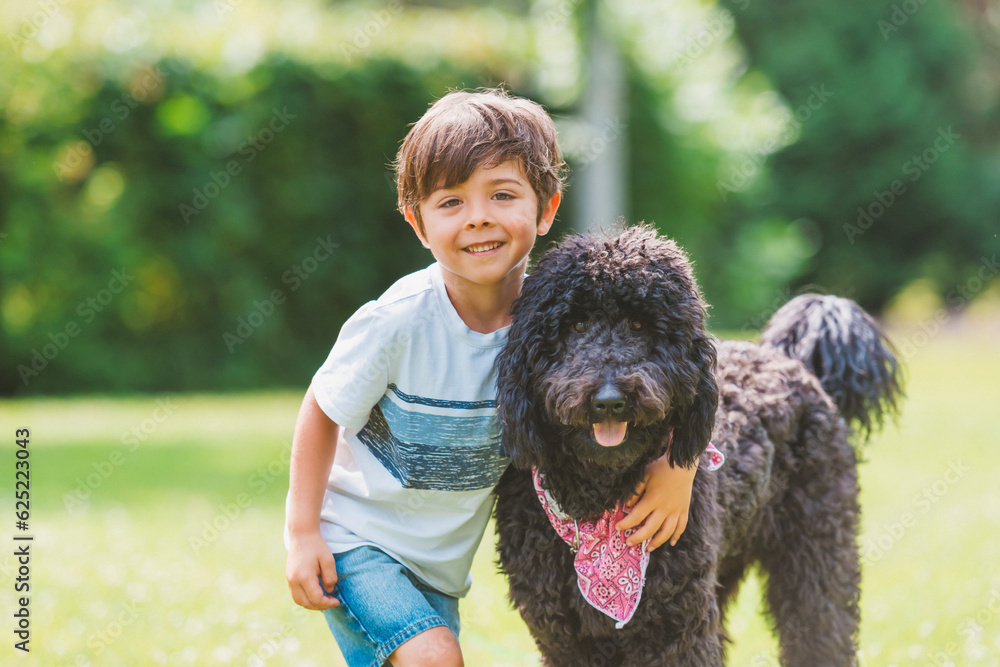 boy with a goldendoodle dog in the park boy with a goldendoodle dog in the park